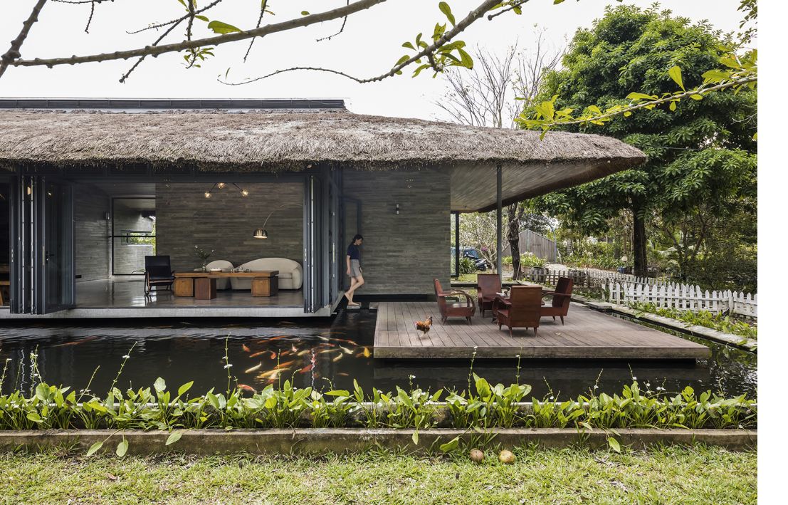 Góc chill ngoài trời của homestay nhà vườn cấp 4 với hồ cá và tiểu cảnh xanh mát